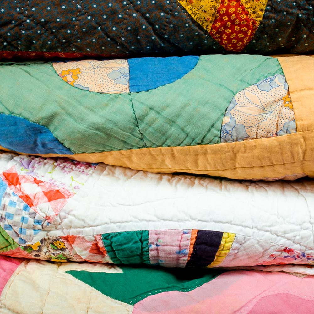 stack of vintage quilts