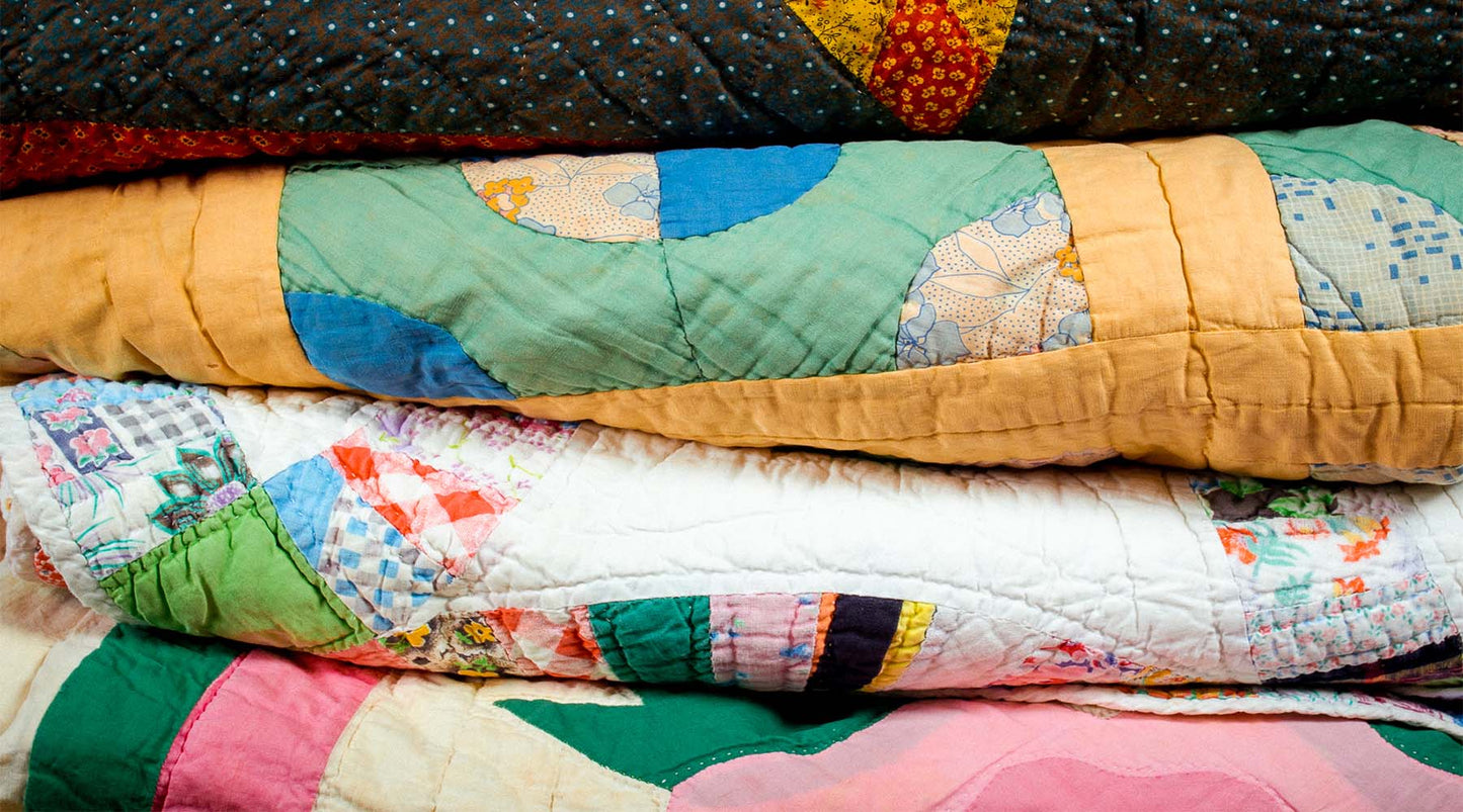 stack of vintage quilts